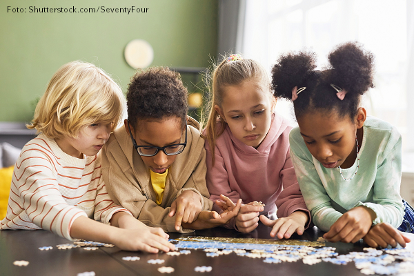 Interkulturelles Lernen Kinder verschiedener Nationalitäten arbeiten an einem Puzzle