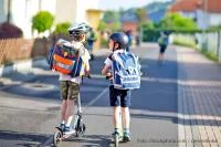 Schulwege Zwei Jungen mit dem Roller auf dem Weg zur Schule